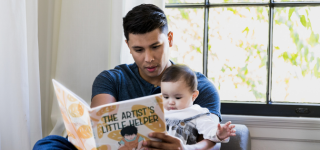 Adult reading to baby.