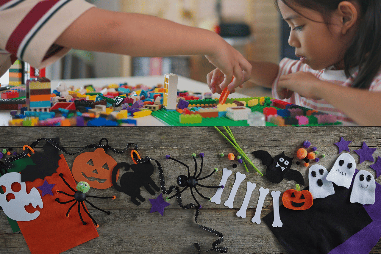children doing legos and halloween crafts on a wood abckround.
