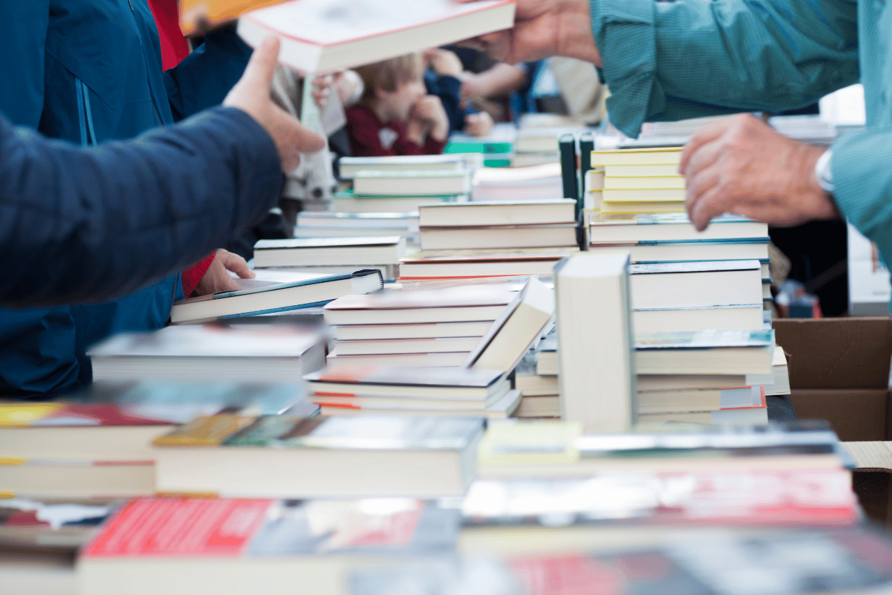 Books on a table with people browsing