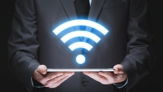 Person in a suit with a glowing Wi-Fi symbol in front of them.