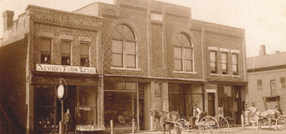 Sepia photo of the Newton Falls Echo office with horses and buggies parked in front.