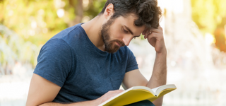 Bearded man reading a book.