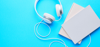 Pair of headphones beside a pair of books.