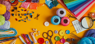 Craft supplies (rhinestones, scissors, yarn, colored pencils, felt, buttons, and beads) spread out across a yellow background image.