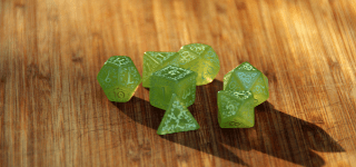 Translucent green polyhedral dice on a wooden table